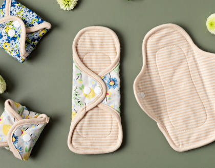 Four reusable menstrual pads on a green background.