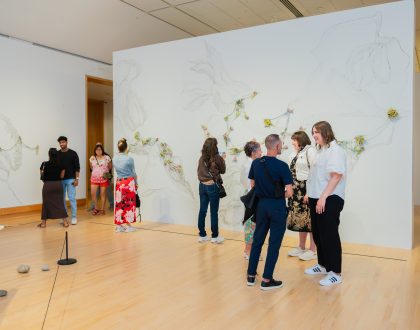 A group of visitors chatting in an art exhibition space.