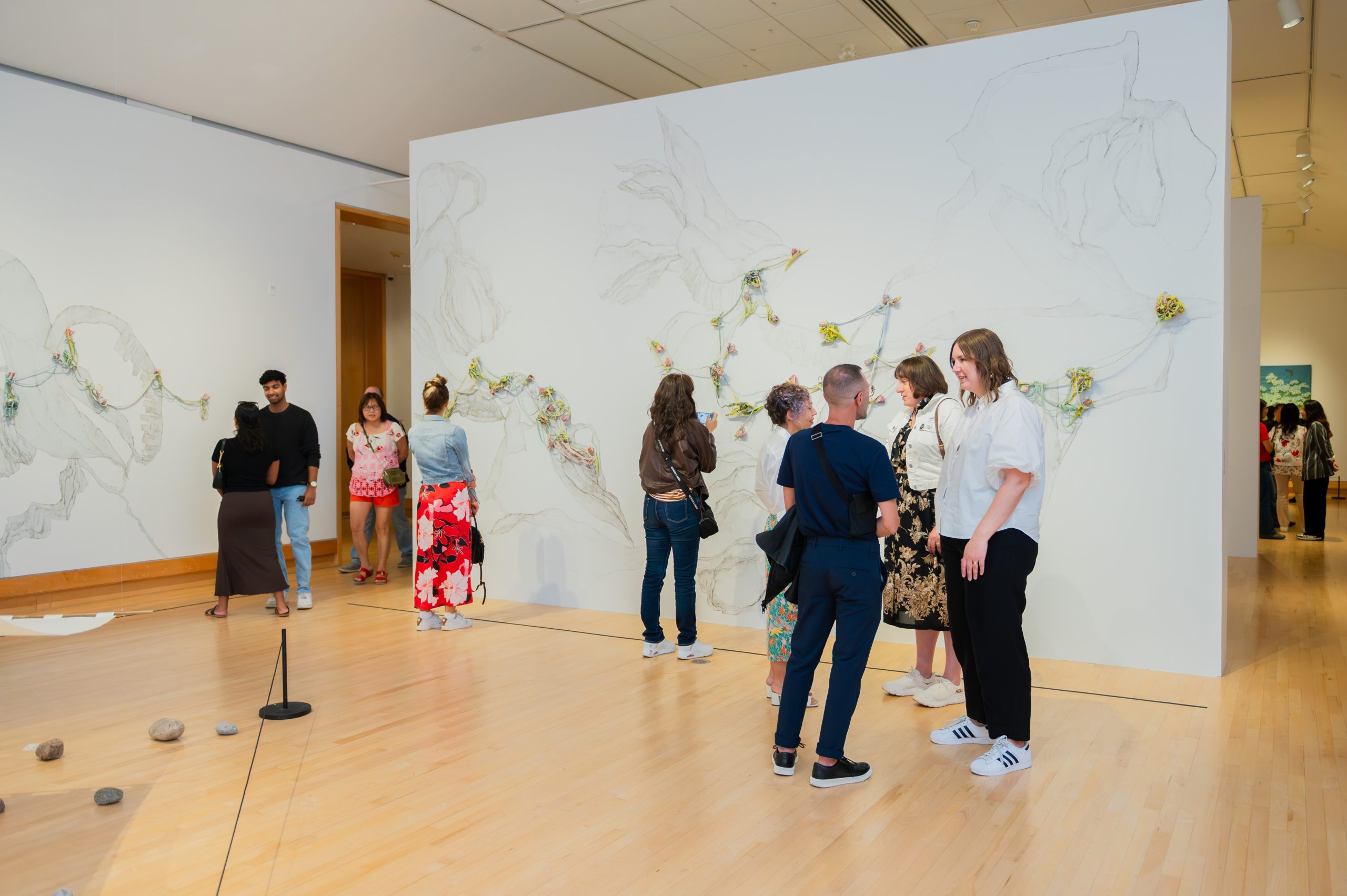 A group of visitors chatting in an art exhibition space.