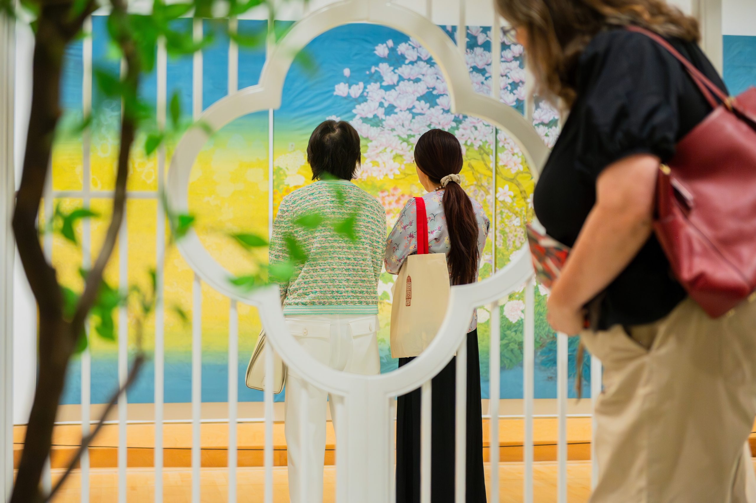 Three visitors viewing a Chinese gongbi landscape painting in the Varley Art Gallery of Markham.