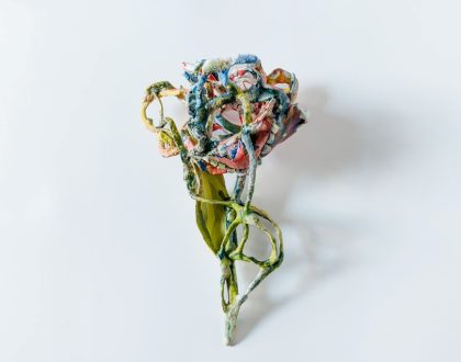 A ceramic multicoloured flower sculpture by Jess Riva Cooper. Placing on a white background.